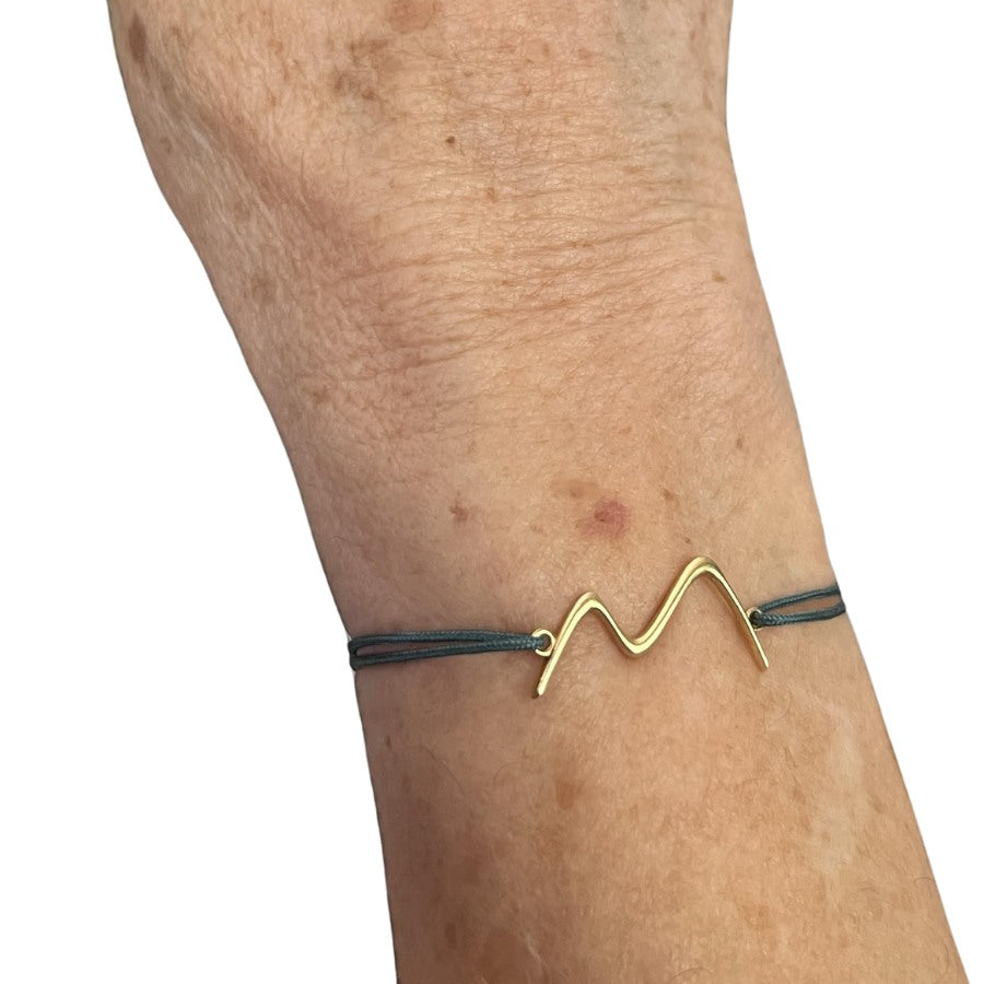 Pulsera macramé oro Eyhses con letra grabada, vista brazo