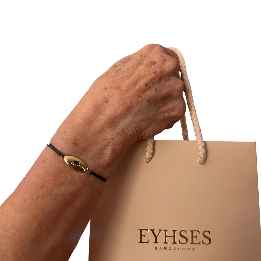 Pulsera macramé con elipse de oro Eyhses, vista con bolsa